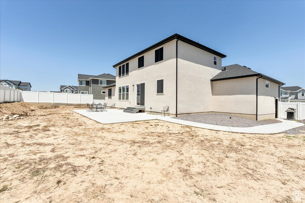 Back of house with a patio, stucco siding, and entry steps