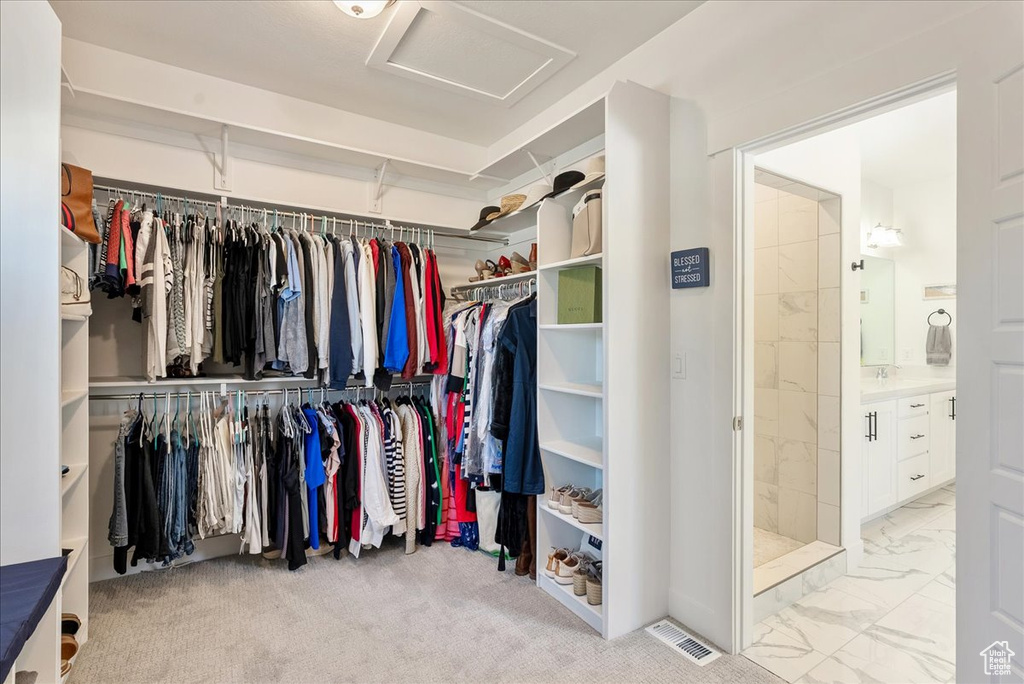 Spacious closet with attic access and marble look tile flooring