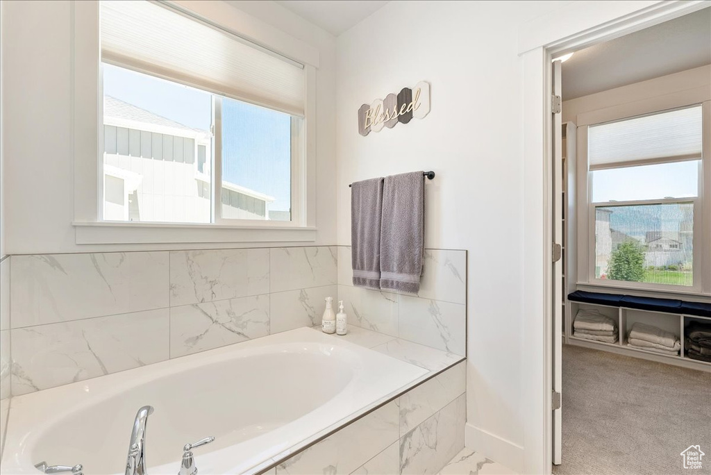 Full bathroom with healthy amount of natural light and a garden tub