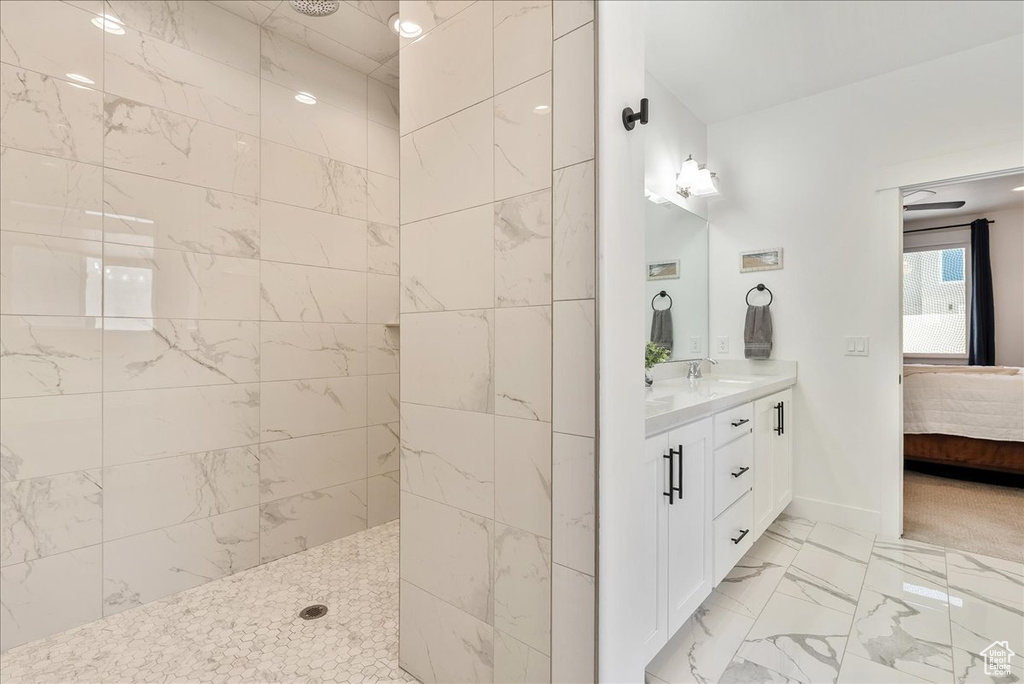 Ensuite bathroom with marble look tiles, vanity, and a walk in shower