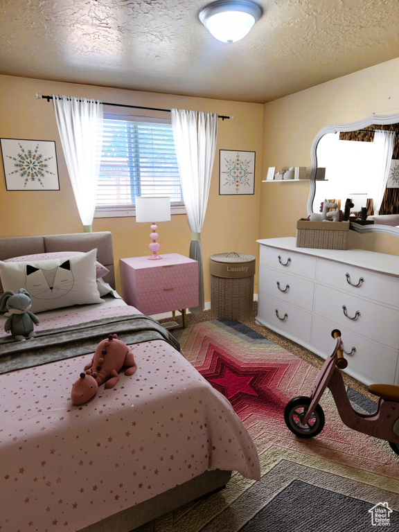 Carpeted bedroom with a textured ceiling and baseboards