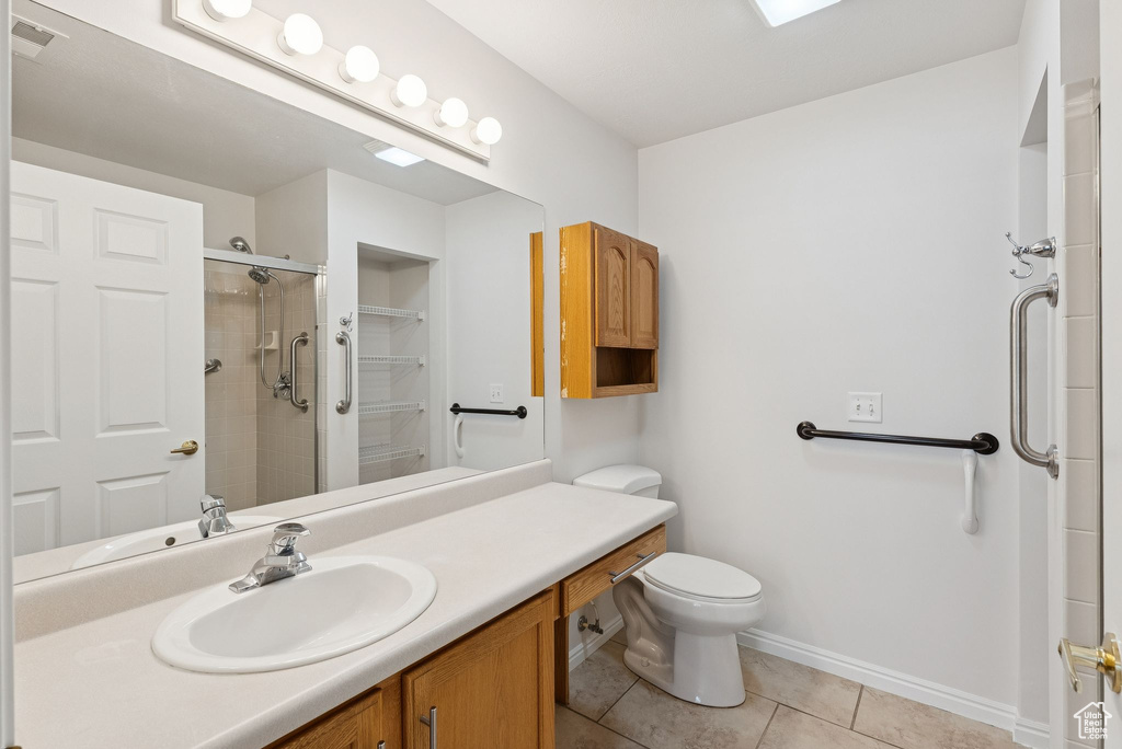 Full bathroom featuring tile patterned flooring, vanity, and a shower with shower door