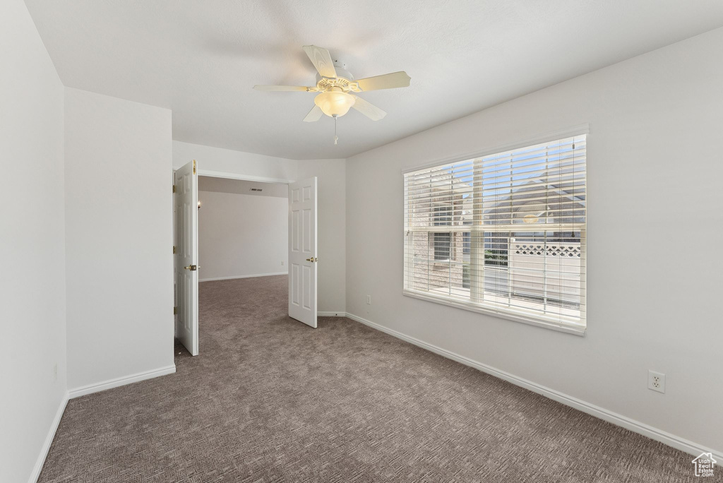 Empty room with ceiling fan and carpet flooring