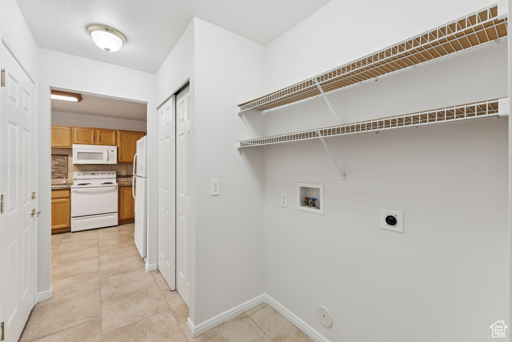 Laundry room with hookup for a washing machine, gas dryer hookup, hookup for an electric dryer, and light tile patterned floors