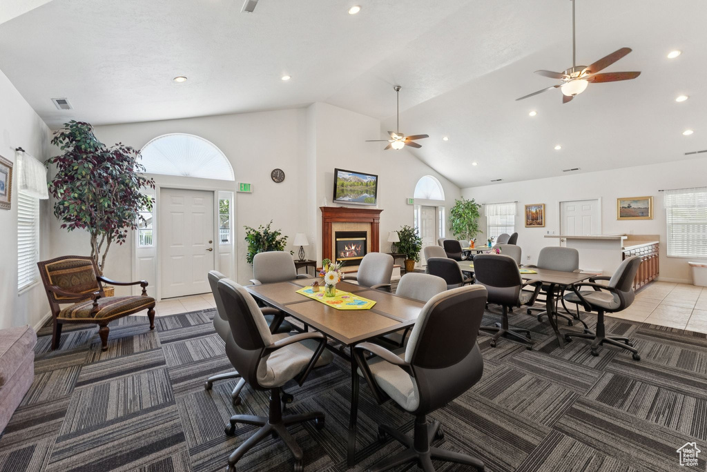 Dining room with ceiling fan, recessed lighting, a glass covered fireplace, high vaulted ceiling, and tile patterned floors
