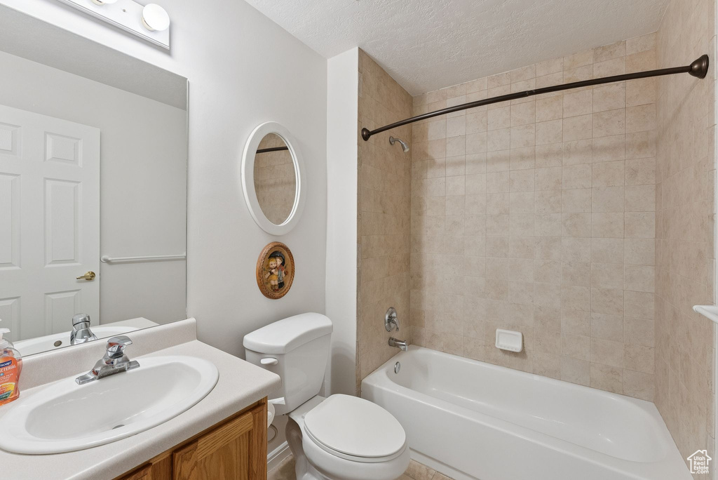 Bathroom with shower / washtub combination, a textured ceiling, and vanity