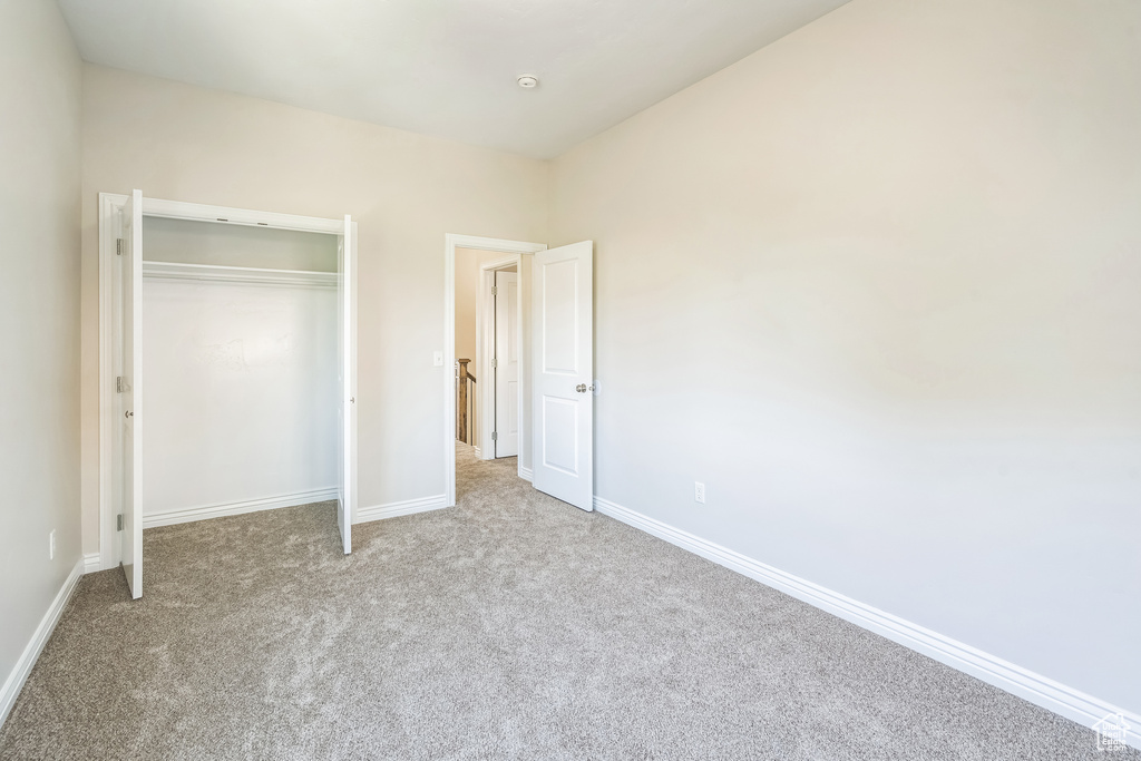 Unfurnished bedroom featuring carpet and a closet