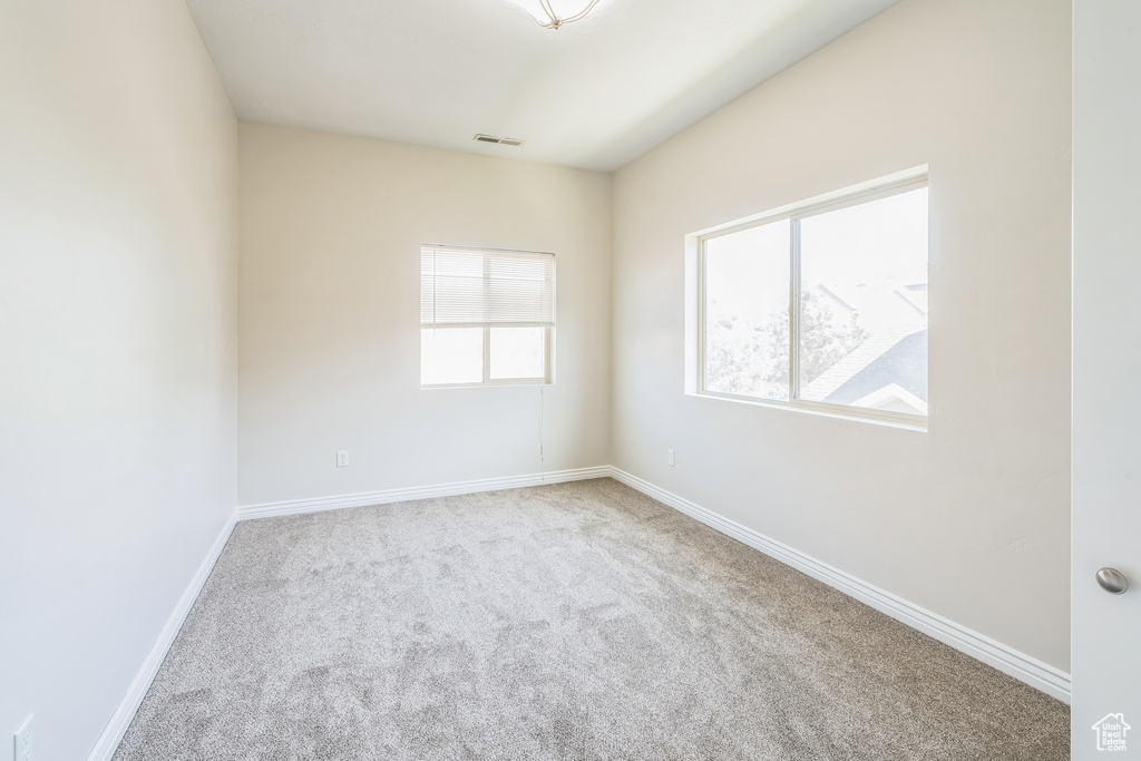 Carpeted empty room featuring baseboards