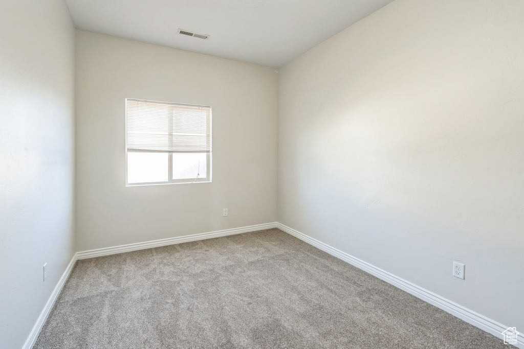 Spare room featuring carpet floors and baseboards