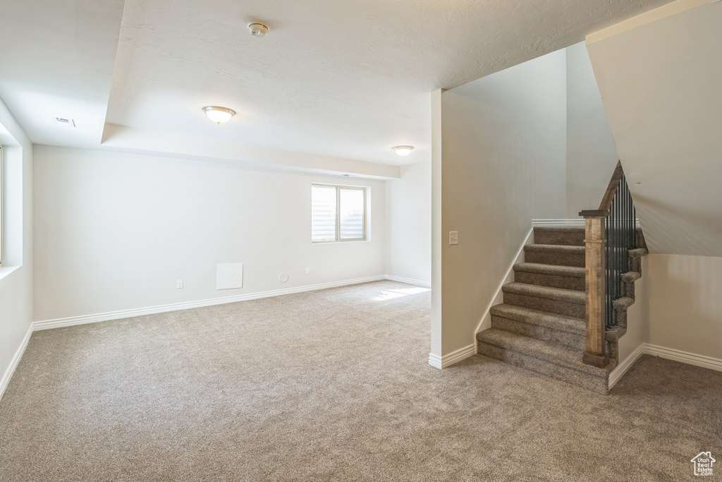 Basement with carpet flooring and stairway