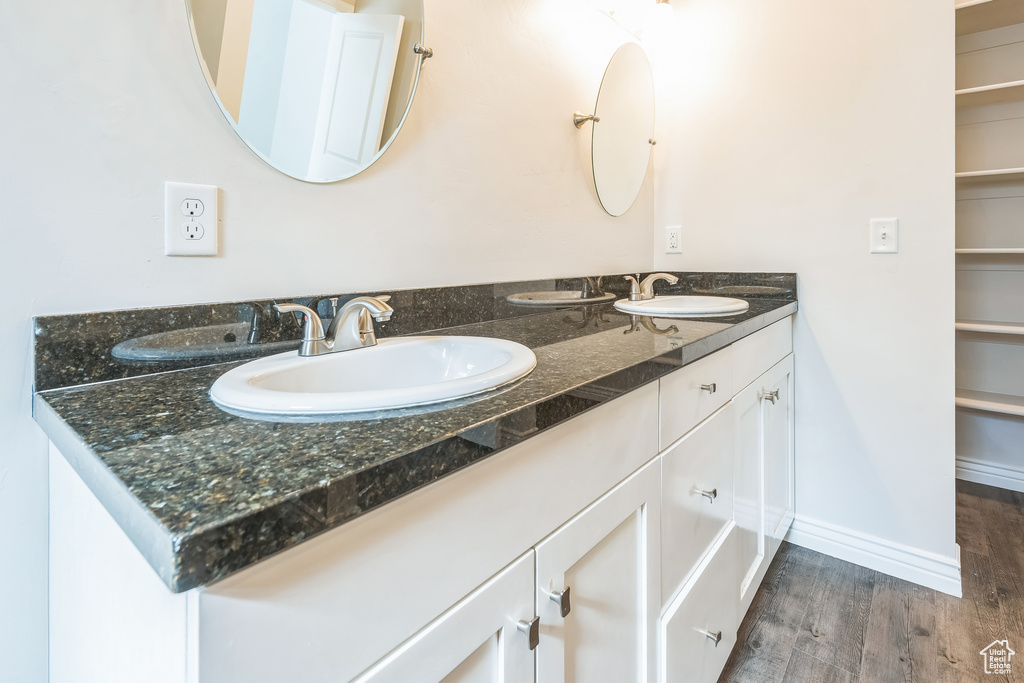 Full bathroom featuring double vanity and wood finished floors