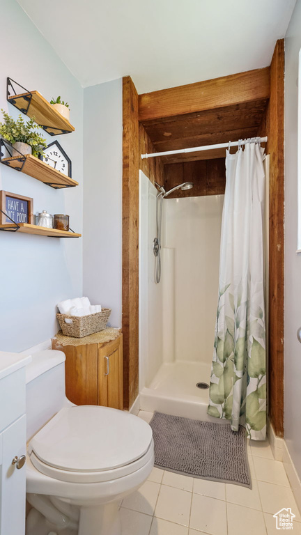 Bathroom featuring a shower with shower curtain, tile patterned floors, and vanity