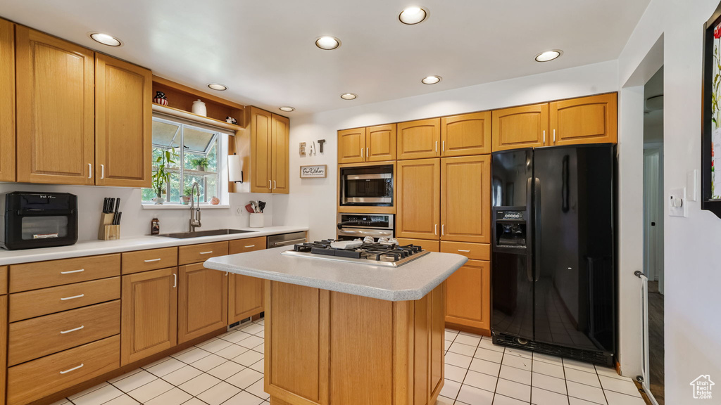 Kitchen with stainless steel appliances, light countertops, a kitchen island, light tile patterned floors, and recessed lighting