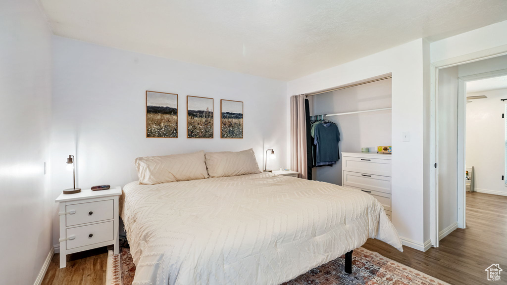 Bedroom with wood finished floors and a closet