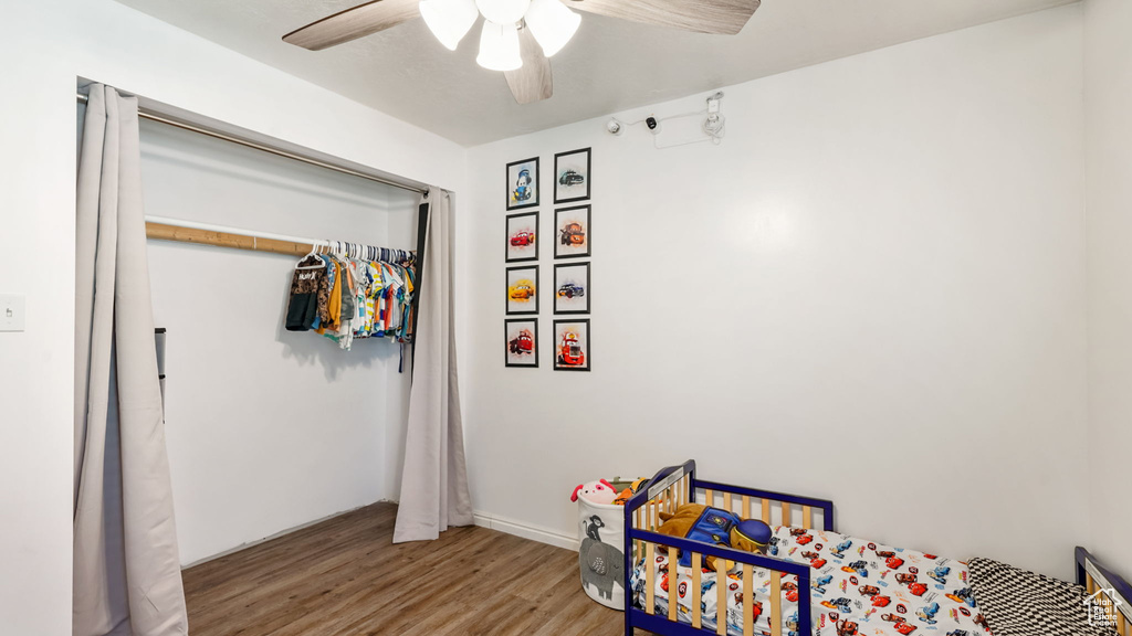 Bedroom featuring wood finished floors, a ceiling fan, and a closet