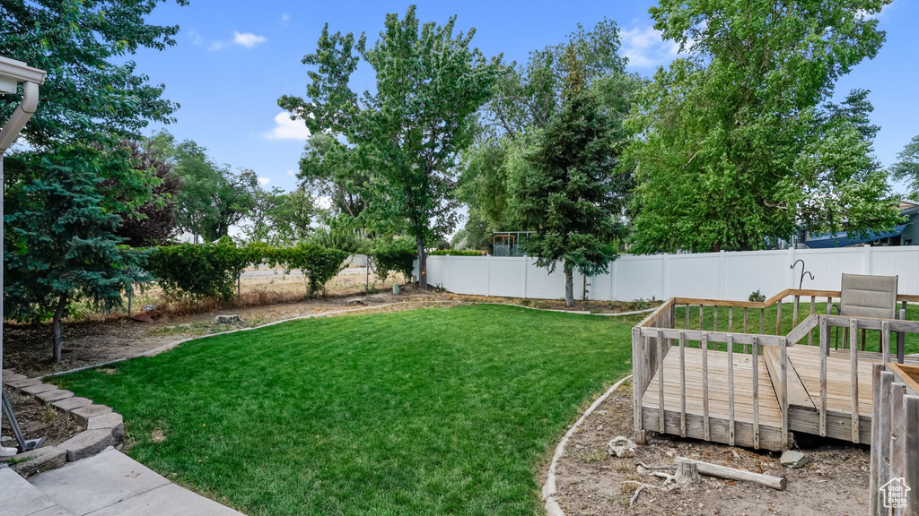 Fenced backyard featuring a deck