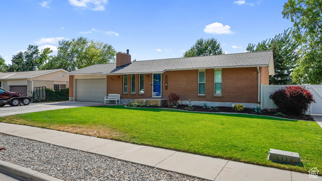 Single story home featuring brick siding, a garage, driveway, a chimney, and a shingled roof