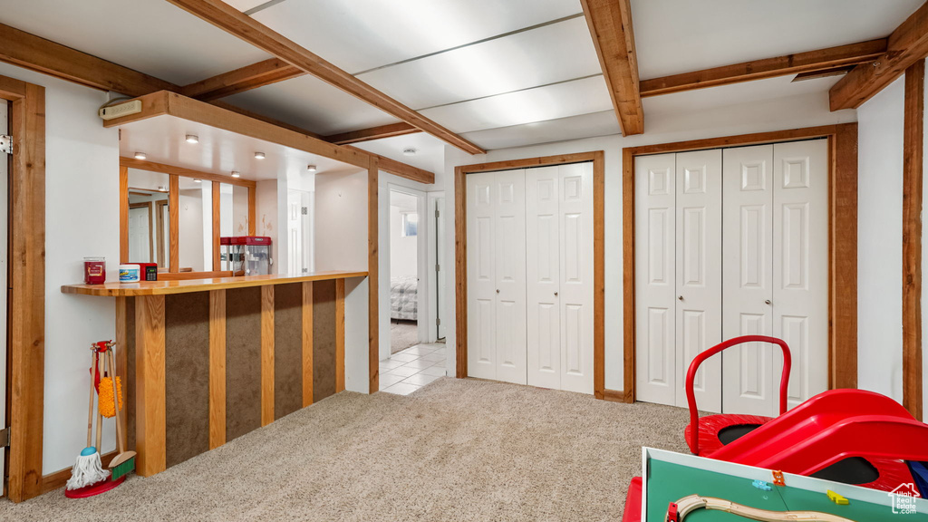 Playroom with carpet floors and beam ceiling