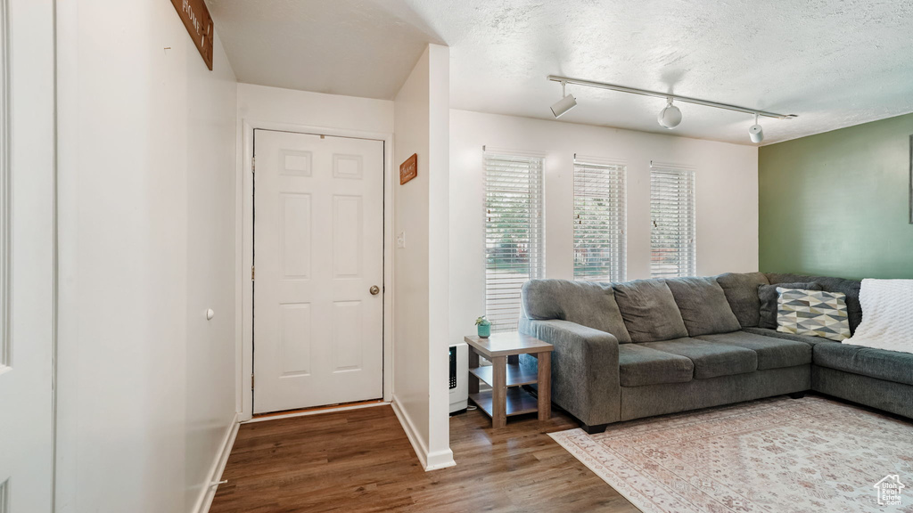 Living room with wood finished floors and rail lighting