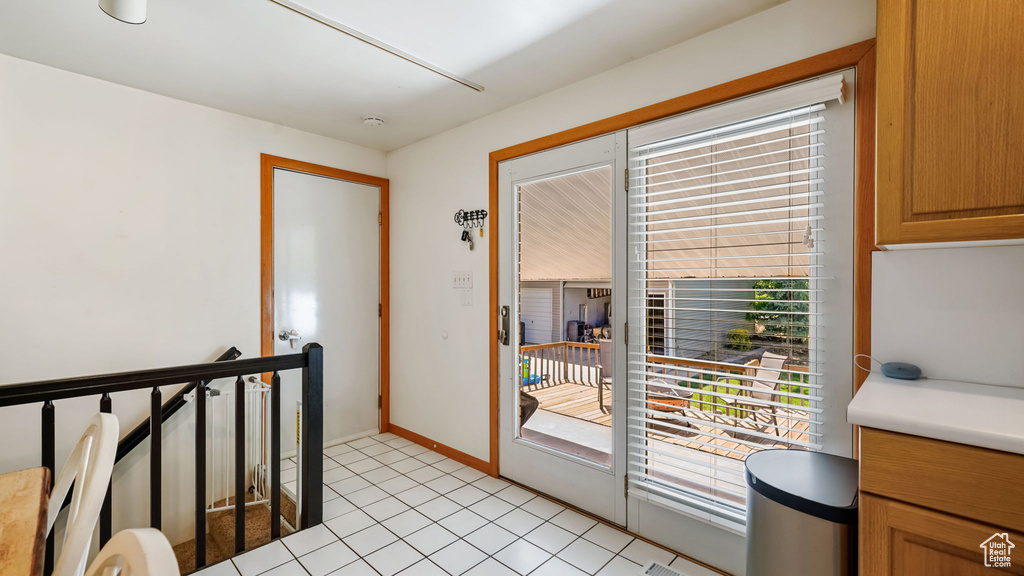 Doorway featuring baseboards and light tile patterned flooring