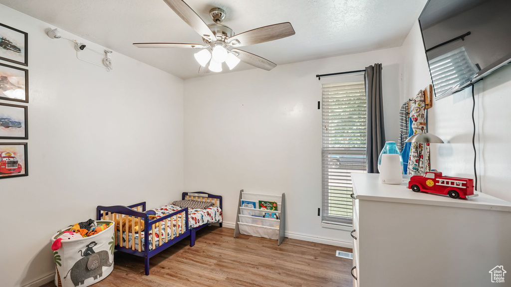 Bedroom with light wood finished floors and a ceiling fan