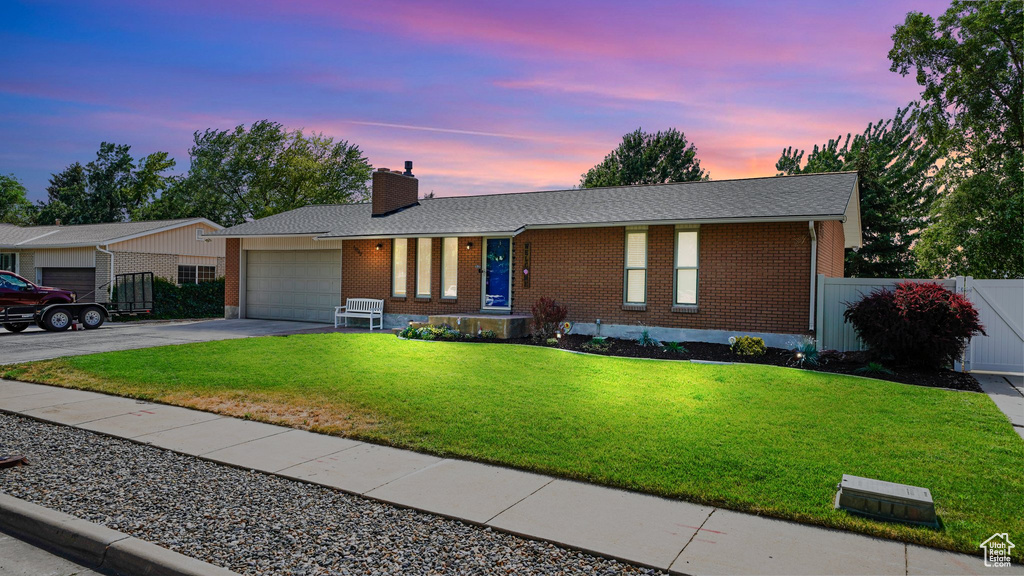 Ranch-style house featuring brick siding, asphalt driveway, a garage, a chimney, and roof with shingles
