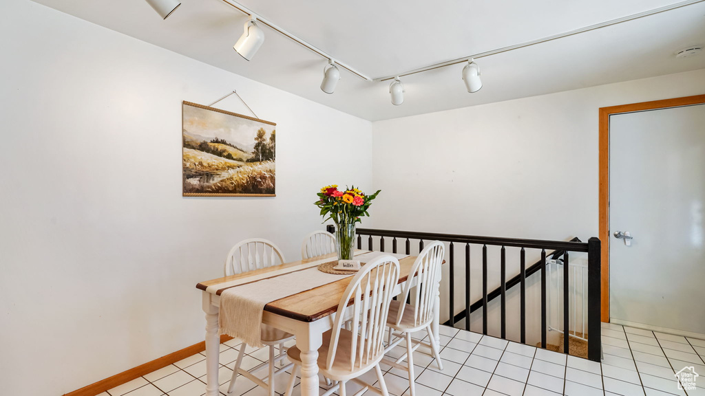 Dining area with rail lighting and light tile patterned floors