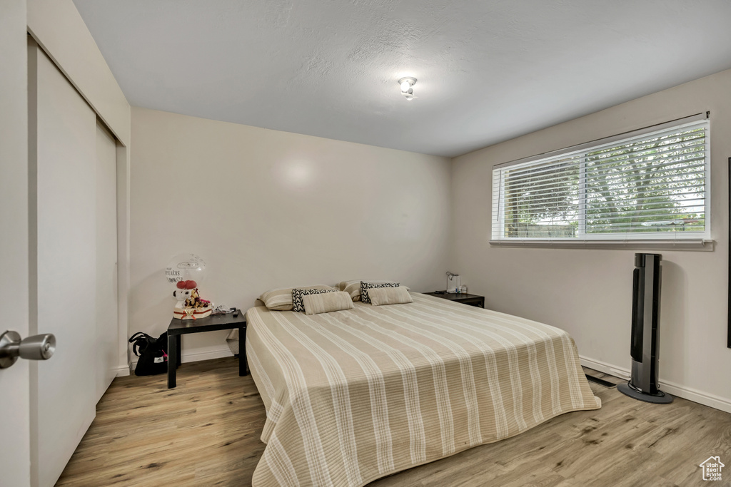 Bedroom featuring light wood finished floors and a closet