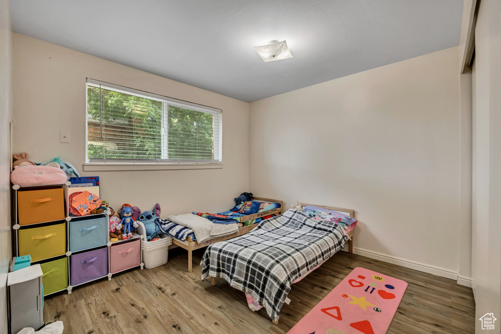 Bedroom with wood finished floors and baseboards