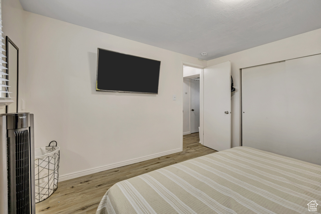 Bedroom featuring wood finished floors and a closet
