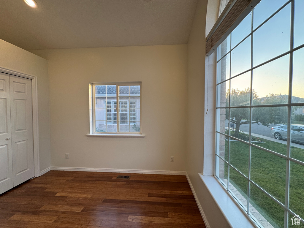 Unfurnished bedroom featuring dark wood-style flooring and a closet