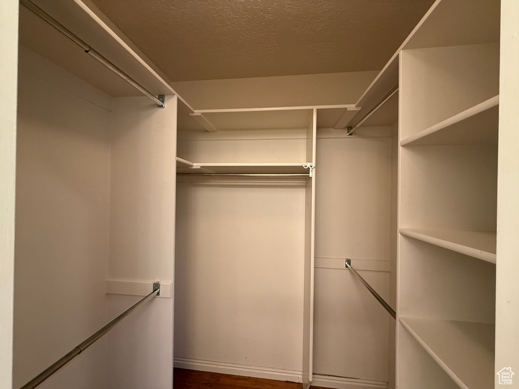Walk in closet featuring dark wood-style floors
