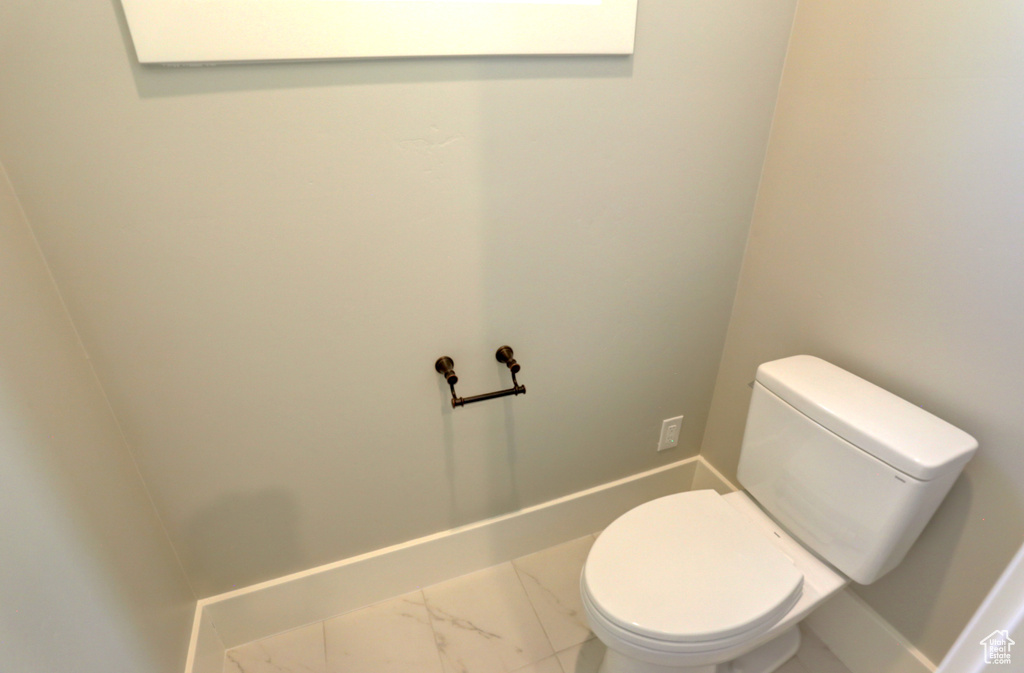 Bathroom with marble look tiles and toilet