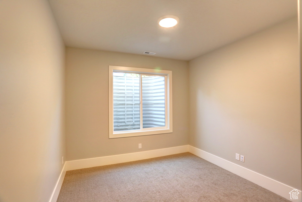 Empty room with baseboards and light colored carpet