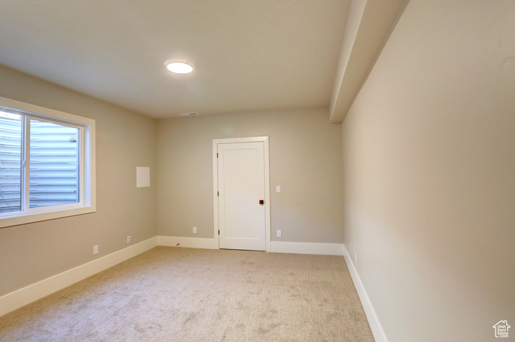 Unfurnished room with light colored carpet and baseboards