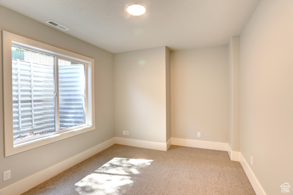 Unfurnished room with light colored carpet and baseboards