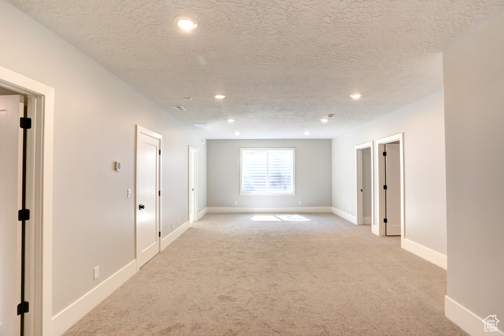 Spare room with light carpet, recessed lighting, and a textured ceiling