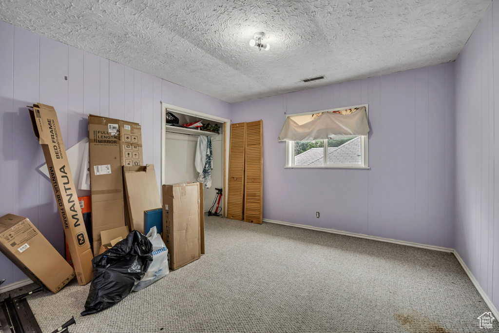 Unfurnished bedroom featuring carpet flooring, a closet, and a textured ceiling