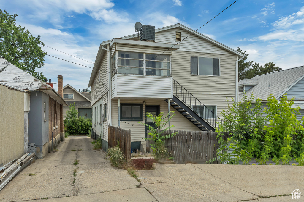View of front of home featuring stairs and concrete driveway