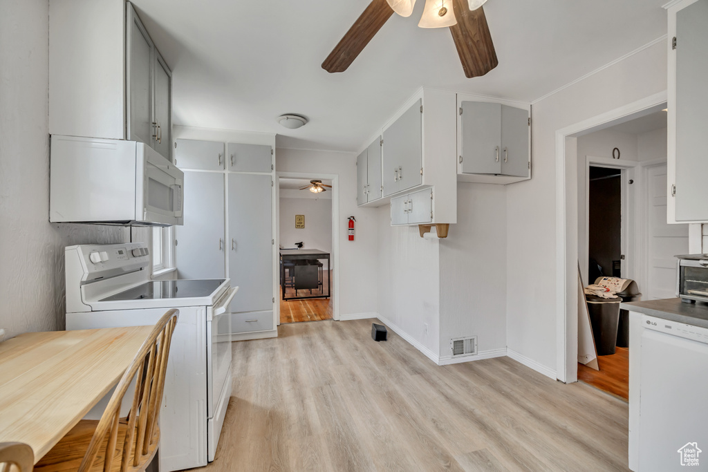 Kitchen featuring a ceiling fan, white appliances, light wood-type flooring, and gray cabinetry