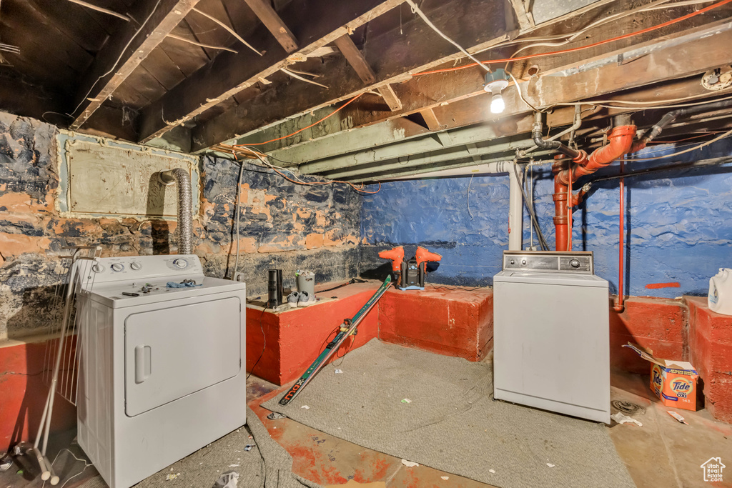 Unfinished below grade area featuring washing machine and clothes dryer
