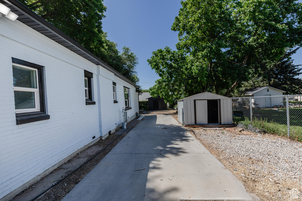 View of property exterior featuring a storage unit and crawl space