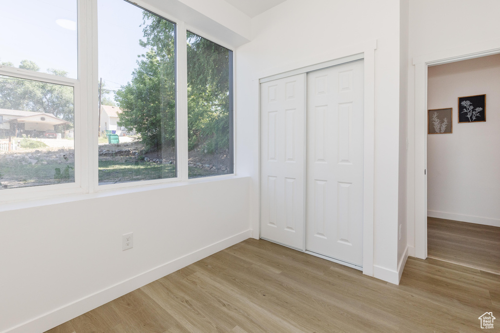 Unfurnished bedroom featuring light wood-style floors and a closet