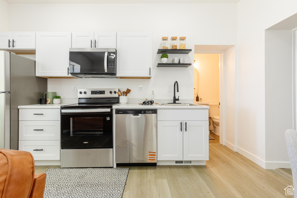 Kitchen featuring stainless steel appliances, light wood finished floors, and light countertops