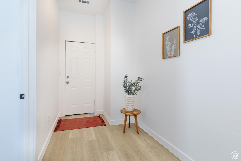 Doorway with light wood-style flooring and baseboards