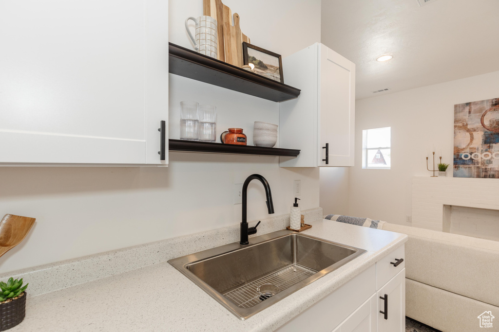 Kitchen with open shelves, white cabinets, and recessed lighting