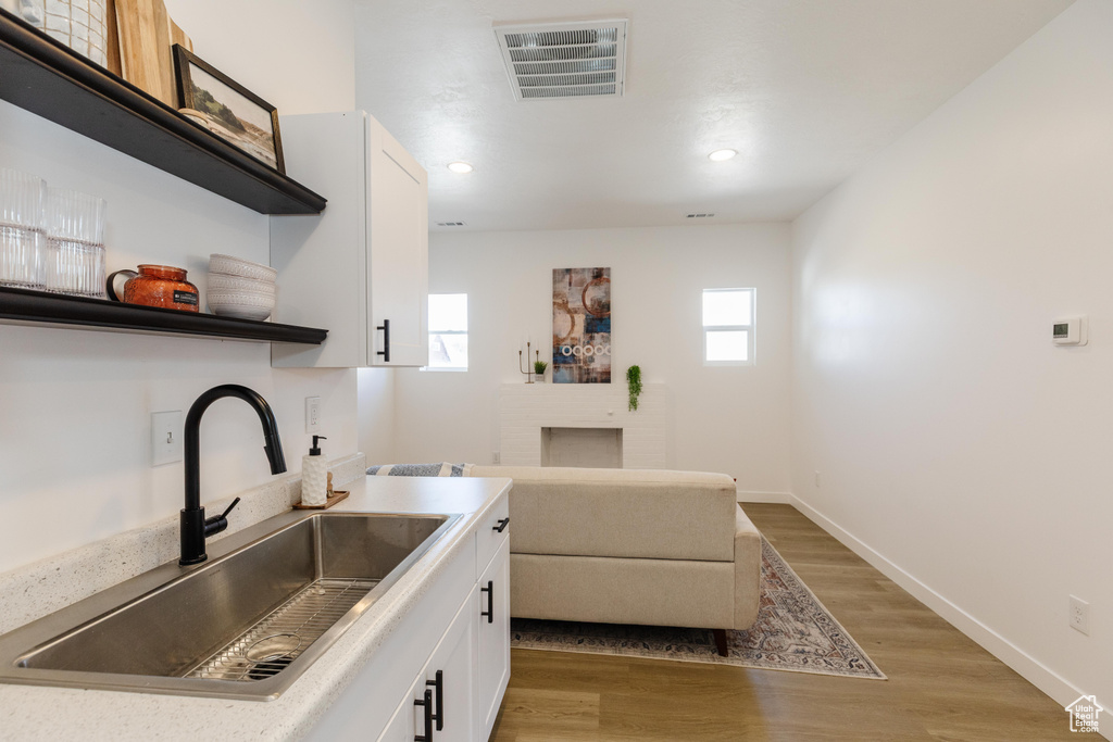 Kitchen featuring open shelves, white cabinetry, light wood finished floors, light countertops, and recessed lighting