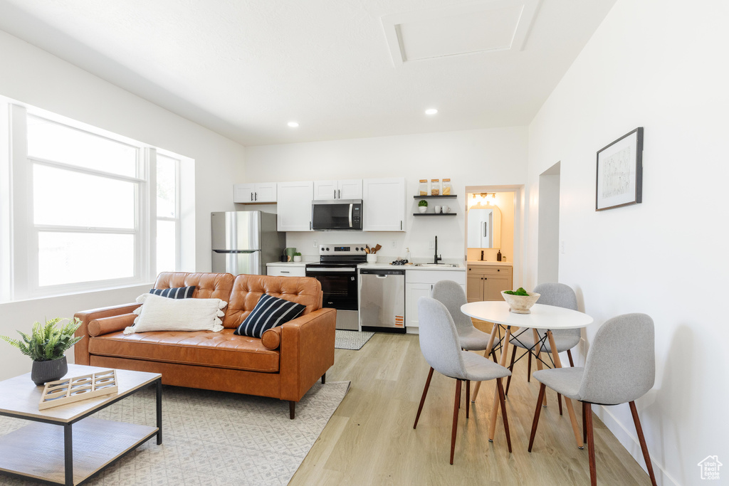 Living area with light wood-style floors, attic access, and recessed lighting