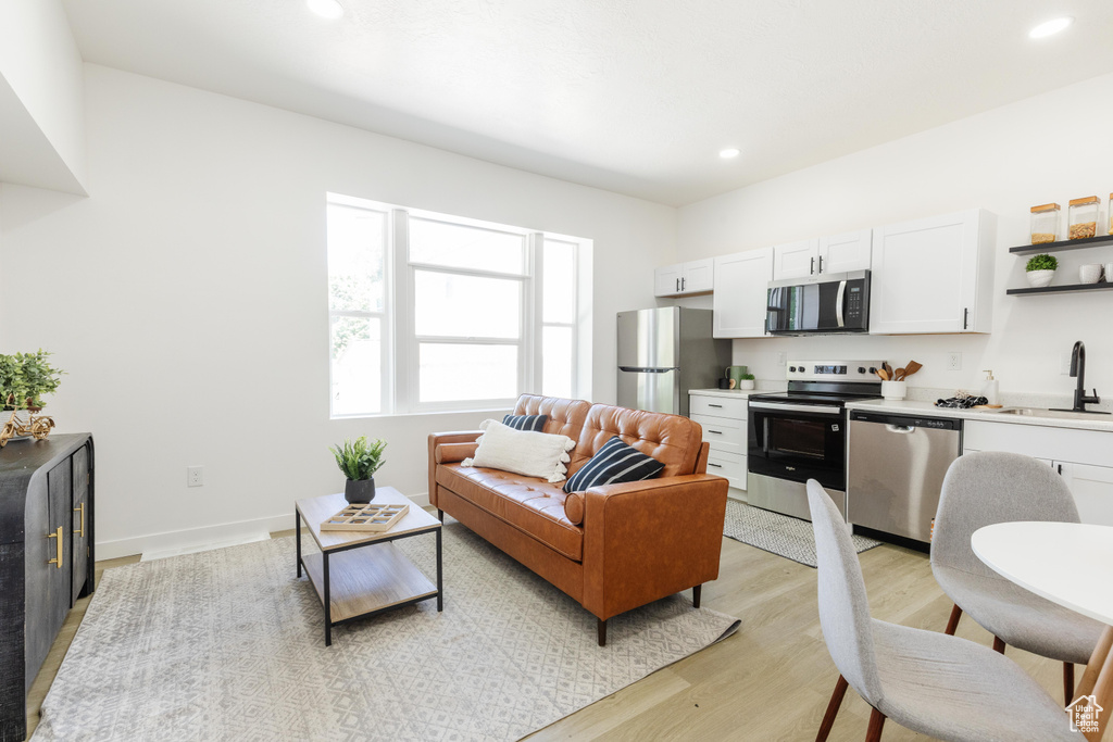 Living room featuring light wood-style flooring and recessed lighting