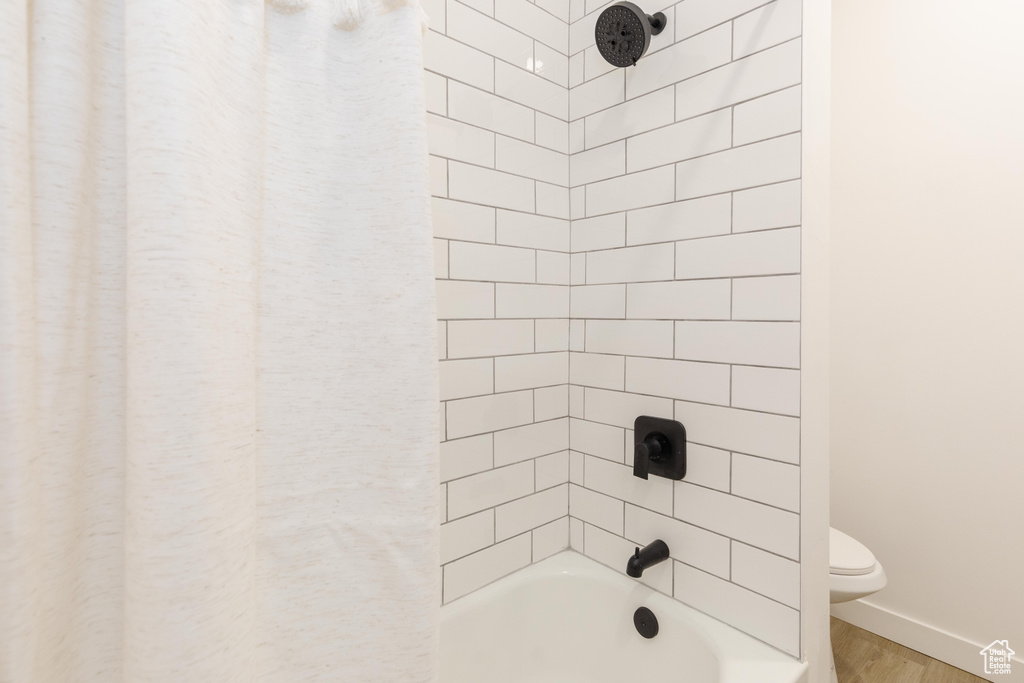 Bathroom featuring wood finished floors and shower / bath combination